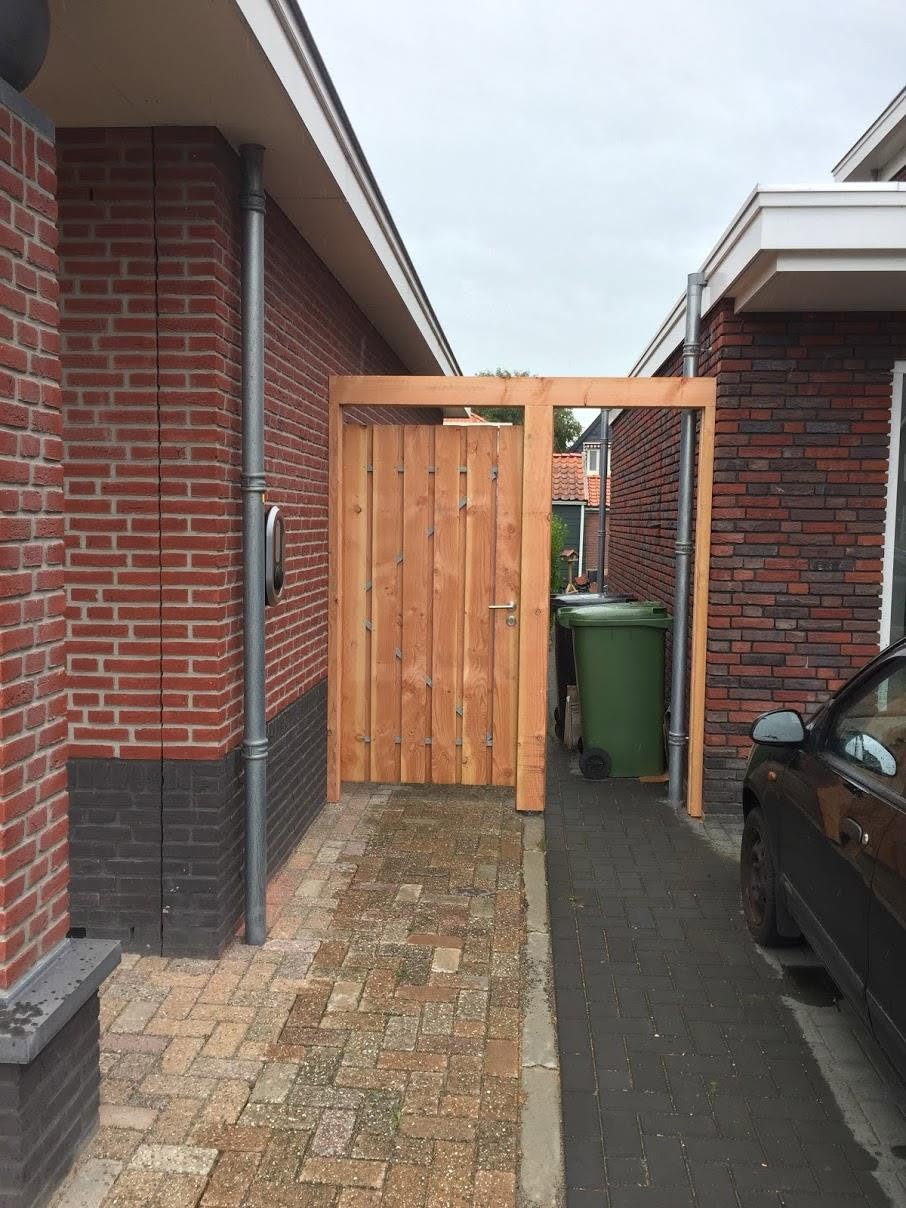 Houten toegangspoort met bovenregel tussen twee woningen