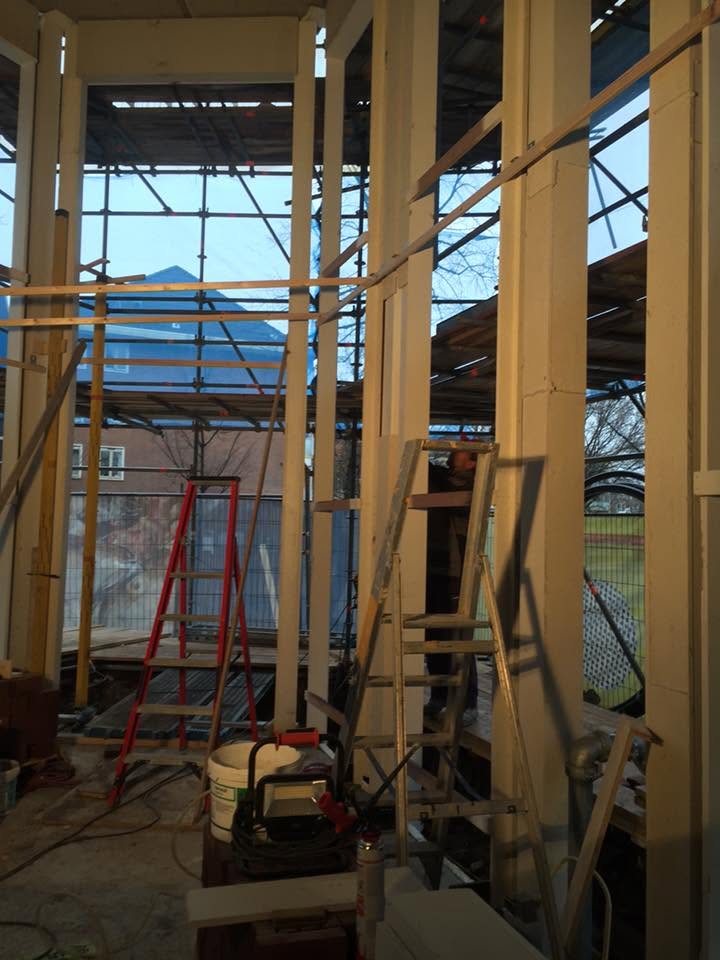 Houtskeletbouw met stelposten en steigerwerk in aanbouw
